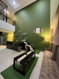 a living room with a couch and a green wall at Villa Verde Guest House in General Santos