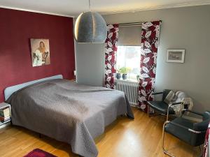a bedroom with a bed and a chair and a window at Lägenhet centralt i Mora in Mora