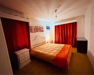 a bedroom with red drapes and a bed in a room at Margarita´s Ville in Costa Nova