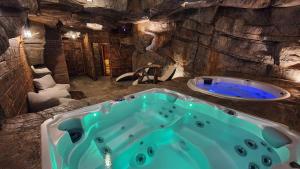 a bathroom with a blue tub in a cave at Domek Hobbita z jaskinią SPA - Osada Jaworzyny in Tokarnia