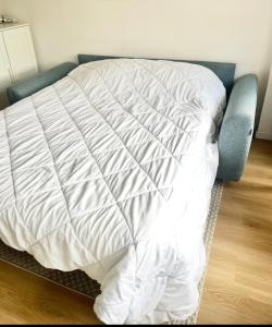 a bed with a white comforter in a bedroom at Studio à 2 pas de la plage! in Hossegor