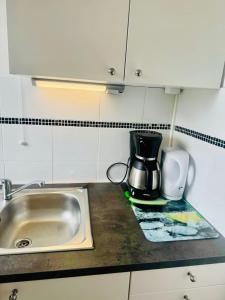 a kitchen counter with a sink and a coffee maker at Studio, sea side in Berck-sur-Mer