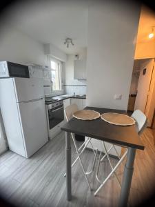 a small kitchen with a table and a refrigerator at Studio, sea side in Berck-sur-Mer
