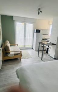 a living room with a kitchen and a bed and a table at Studio, sea side in Berck-sur-Mer