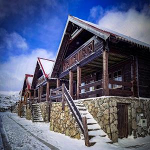 a log cabin in the snow with stairs in front at Chalé do Zêzere in Cortes do Meio