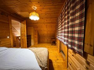 a bedroom with a bed in a wooden cabin at Chalé do Zêzere in Cortes do Meio