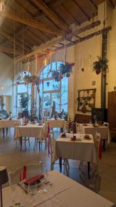 a dining room with white tables and chairs and chandeliers at Antico Podere Emilia in Reggio Emilia