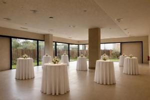 a room with white tables with flowers on them at Hotel Punta Bermeja Premium in El Puerto de Santa María +43 photos