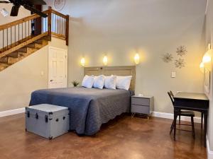 a bedroom with a bed with a staircase and a desk at Haven at Hazel - the Residence in Demorest