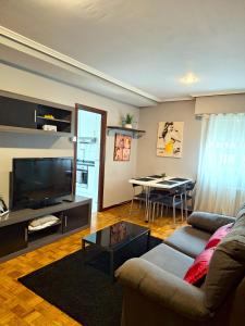 a living room with a couch and a tv and a table at Parque da Ponte in Ourense