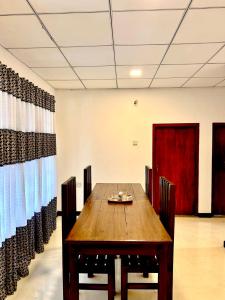 a dining room with a wooden table and chairs at The horezt in Kamburugamuwa