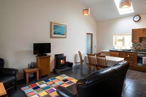 a living room with a table and chairs and a stove at Nancy's Seaside Cottage, Renvyle in Renvyle