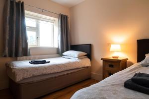 a small bedroom with two beds and a window at Nancy's Seaside Cottage, Renvyle in Renvyle