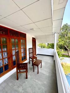 a porch with two chairs and windows on a house at The horezt in Kamburugamuwa