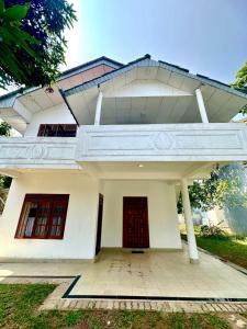 a white house with red doors at The horezt in Kamburugamuwa