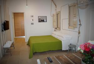 um pequeno quarto com uma cama verde e um lavatório em B&B Zuppetta 16 em Bari