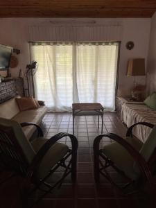 a living room with chairs and a couch and a window at Casa Paso in Paso de la Patria +3 photos