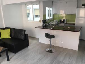 a kitchen with a counter and a chair in a room at Para, Descansa, Siente el mar - bienvenido a Cullera in Cullera