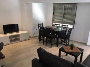 a living room with a table and chairs and a television at Para, Descansa, Siente el mar - bienvenido a Cullera in Cullera