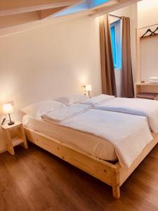 a bedroom with a large bed with two lamps on it at B&B Morbegno in Morbegno