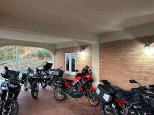 a group of motorcycles parked next to a brick wall at MADONIE Guest House in Petralia Soprana
