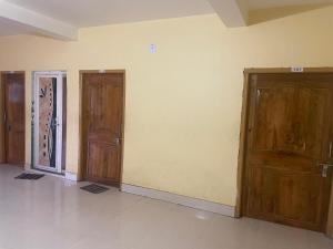 an empty room with two wooden doors on the wall at Care Guest House in Bhubaneshwar