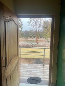 an open door to a balcony with a view of a field at Care Guest House in Bhubaneshwar