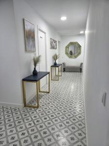 a hallway with two tables and a mirror at LAS CASITAS DE JISA in Talavera de la Reina