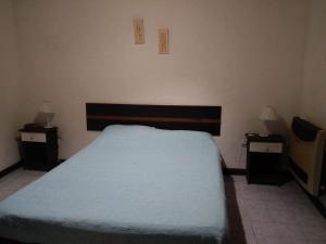a bedroom with a bed and two night stands with two lamps at Casa La micelia in Pinamar