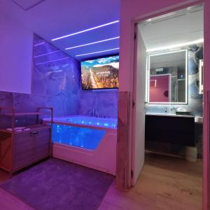 a purple bathroom with a tub and a tv at TOP1 Templum Luxuriae in Reggio di Calabria