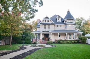 a large white house with a landscaped yard at The Victoria Bed & Breakfast in Bentonville
