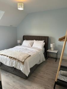 a bedroom with a large bed with white sheets at Clare Cottage in Doolin
