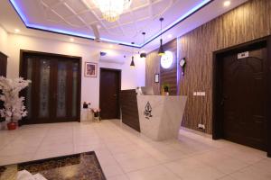 a lobby with two black doors and a counter at Cuzzy Inn Stay in Lahore