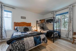 a bedroom with two beds and a bunk bed at Condo Lac Archambault Fireplace beach in Saint-Donat-de-Montcalm