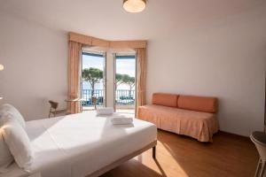 a bedroom with a bed and a couch and a window at LVG Hotel Collection - Majestic in Alassio