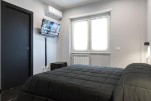 a bedroom with a bed and a tv on the wall at Magami Station Ciampino in Ciampino +19 photos