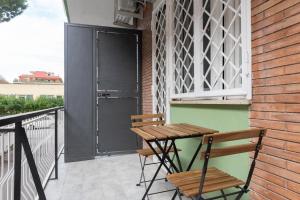 a wooden table and a chair on a balcony at Magami Station Ciampino in Ciampino