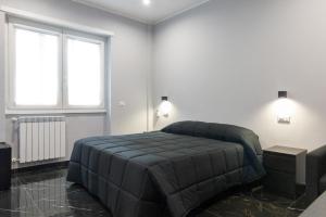 a bedroom with a large bed and two windows at Magami Station Ciampino in Ciampino
