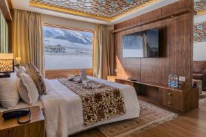 a bedroom with a large bed with a television at Hotel Village Walk in Sonāmarg +61 photos