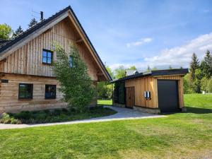 a barn with a garage next to a house at Roubenka Panské Pole in Panské Pole