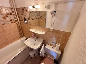 a bathroom with a sink and a toilet and a mirror at Hotel de la gare des Ecrins in LʼArgentière-la-Bessée