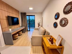 a living room with a couch and a tv at Refúgio Serena in Niterói