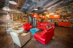a living room with red furniture and a kitchen at Hermann Grain Bins BNB Entire Complex sleeps 16 in Hermann