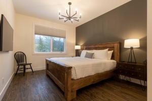 a bedroom with a large bed and a chandelier at Powder House Chalet by Fernie Central Reservations in Fernie