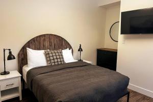 a bedroom with a large bed and a flat screen tv at Powder House Chalet by Fernie Central Reservations in Fernie