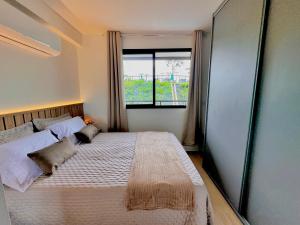a bedroom with a large bed with a window at Refúgio Serena in Niterói +69 photos