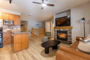 a living room with a kitchen and a fireplace at Riverside Condos by Fernie Central Reservations in Fernie