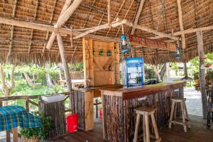 a bar in a restaurant with a straw roof at Afro Beach Safari in Kilindoni