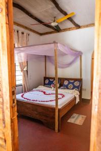 a bedroom with a bed with a canopy at Afro Beach Safari in Kilindoni