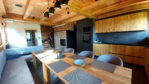 a dining room with a wooden table and a kitchen at Roubenka Panské Pole in Panské Pole
